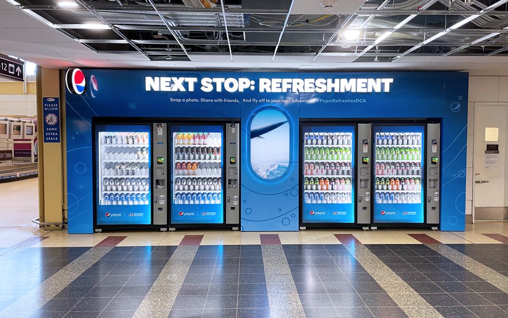 Indoor vending bank enclosure reading Next Stop: Refreshment at Reagan National airport